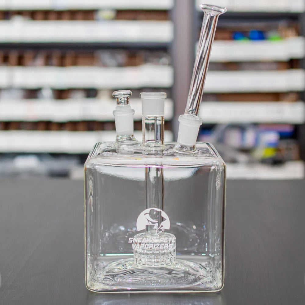 sneaky pete mega cube glass rig with glass mouthpiece sat on grey surface