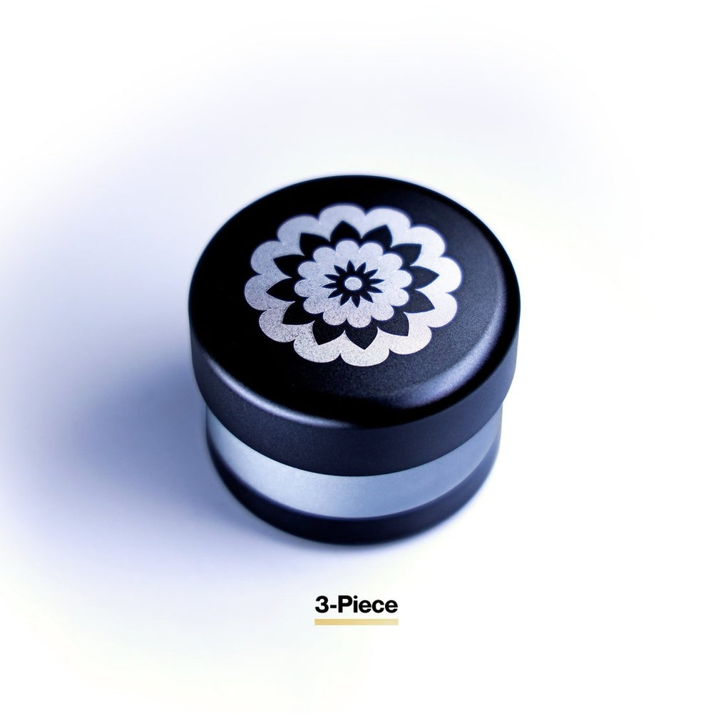  black and grey flowermill 2.5 premium herb grinder with white flowermill branding in 3 separate sections top view on white background
