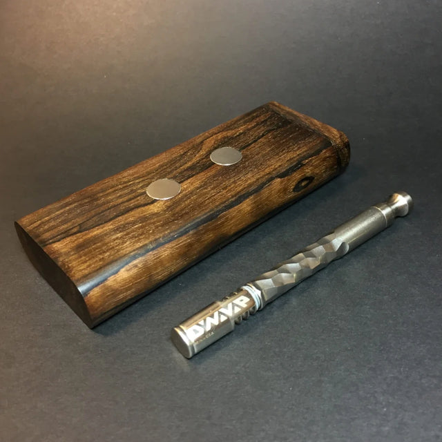 futostash XL G2  for dynavap slaying flat with dynavap OmniVap laying next to it, on grey surface.