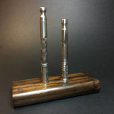 futostash XL G2 for dynavap laying flat on grey background with 2 dynavaps stood upright on futostash magnets