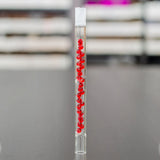 sneaky pete beaded 130mm glass add-a-cap accessory with red beads stood upright on grey surface