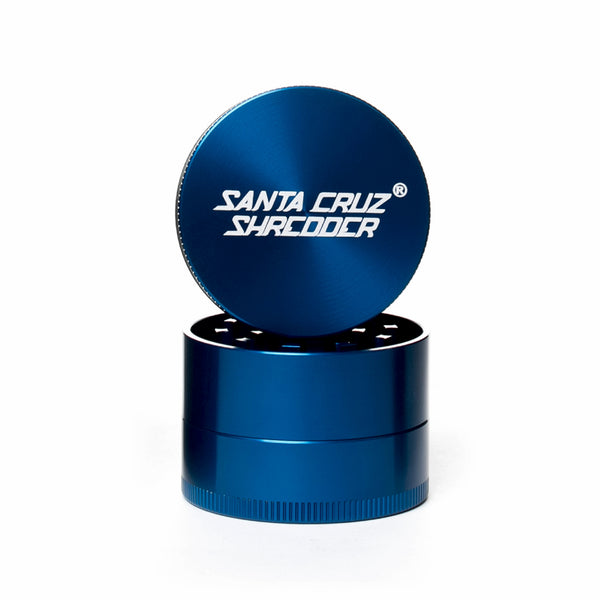Blue circular 2 piece herb grinder with the lid section sitting on top of the base. Santa Cruz logo on lid.