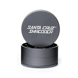 Grey 3 piece santa cruz shredder herb grinder with the lid section sitting on top of the base. Santa Cruz logo on lid.