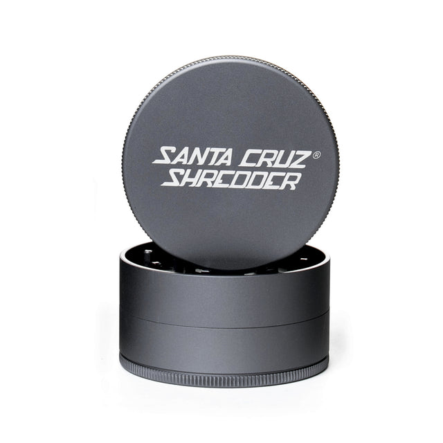 Grey 3 piece santa cruz shredder herb grinder with the lid section sitting on top of the base. Santa Cruz logo on lid.